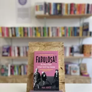 Copi o 'Fabulosa' yn sefyll ar stondin llyfrau, tu blaen silffoedd o lyfrau yn y cefndir.